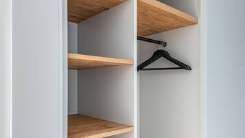 Ein begehbarer Kleiderschrank mit Holzböden und einem schwarzen Kleiderbügel.