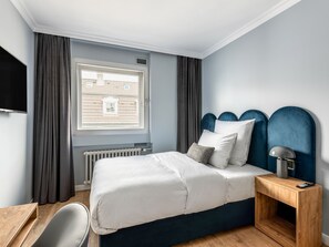 Relax in a spacious room with a large bed, flat-screen TV, and a comfortable nightstand.