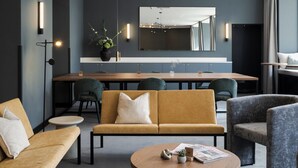 Ett modernt vardagsrum med en soffa, fåtöljer, ett soffbord och en matplats med ett bord och stolar.