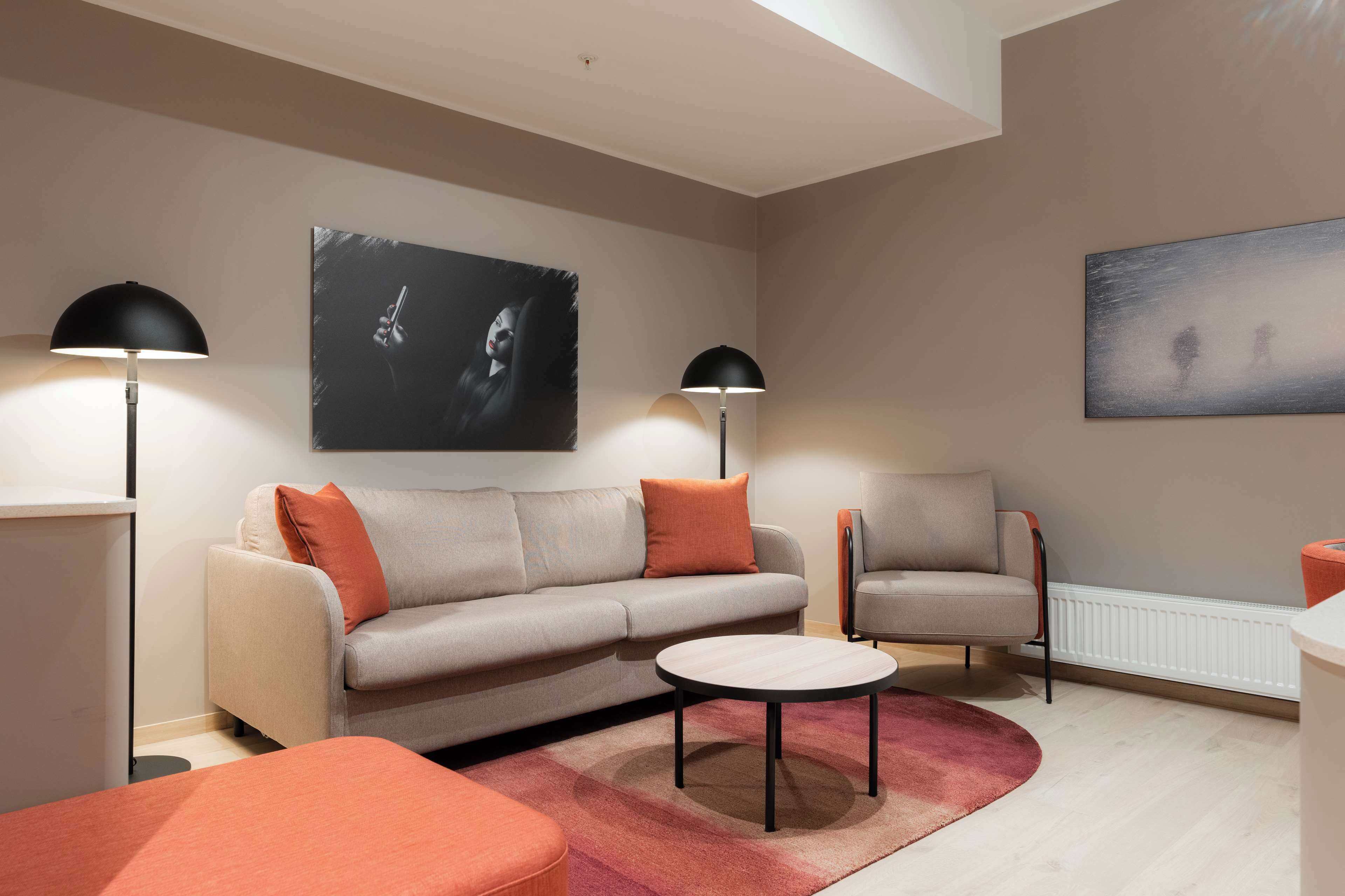 Un salon moderne comprenant un canapé, des fauteuils, une table basse et deux lampadaires.
