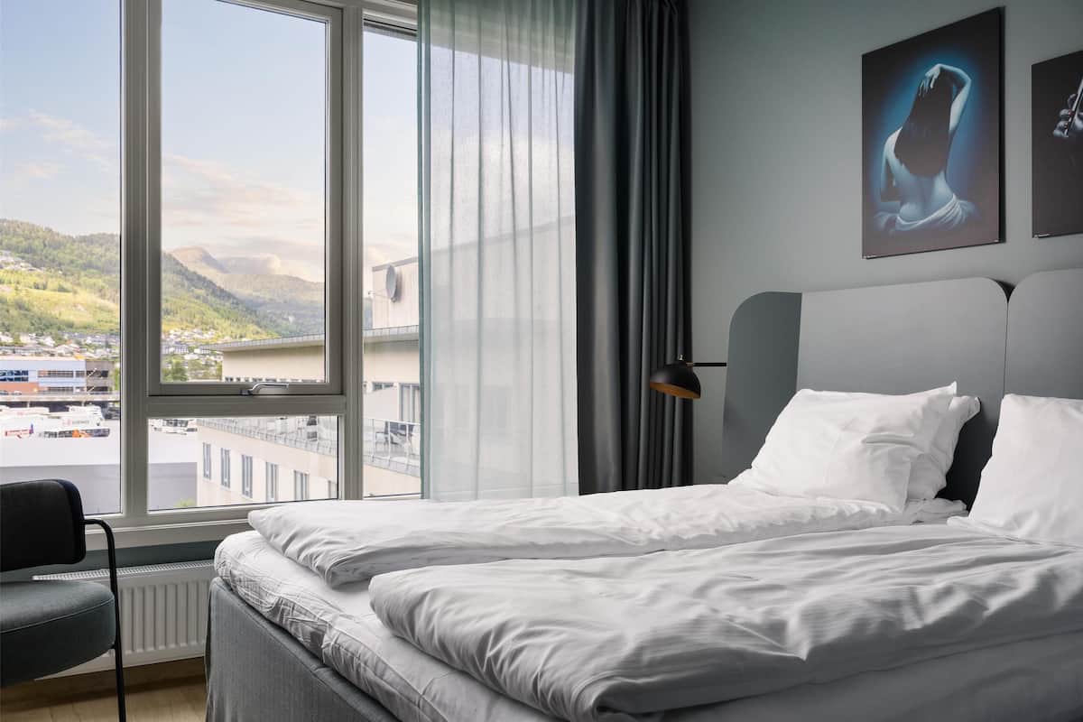 Ein Hotelzimmer mit großem Fenster und Blick auf eine Brücke und die Ferne.
