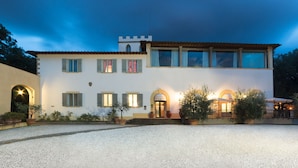 A two-story building with a white facade, multiple windows with shutters, and a gravel driveway. - Hotel Villa Stanley (Sesto Fiorentino)
