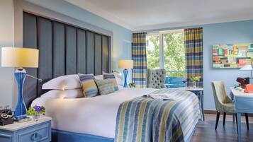 A modern hotel room with a large bed, two bedside tables, a desk, and a chair.