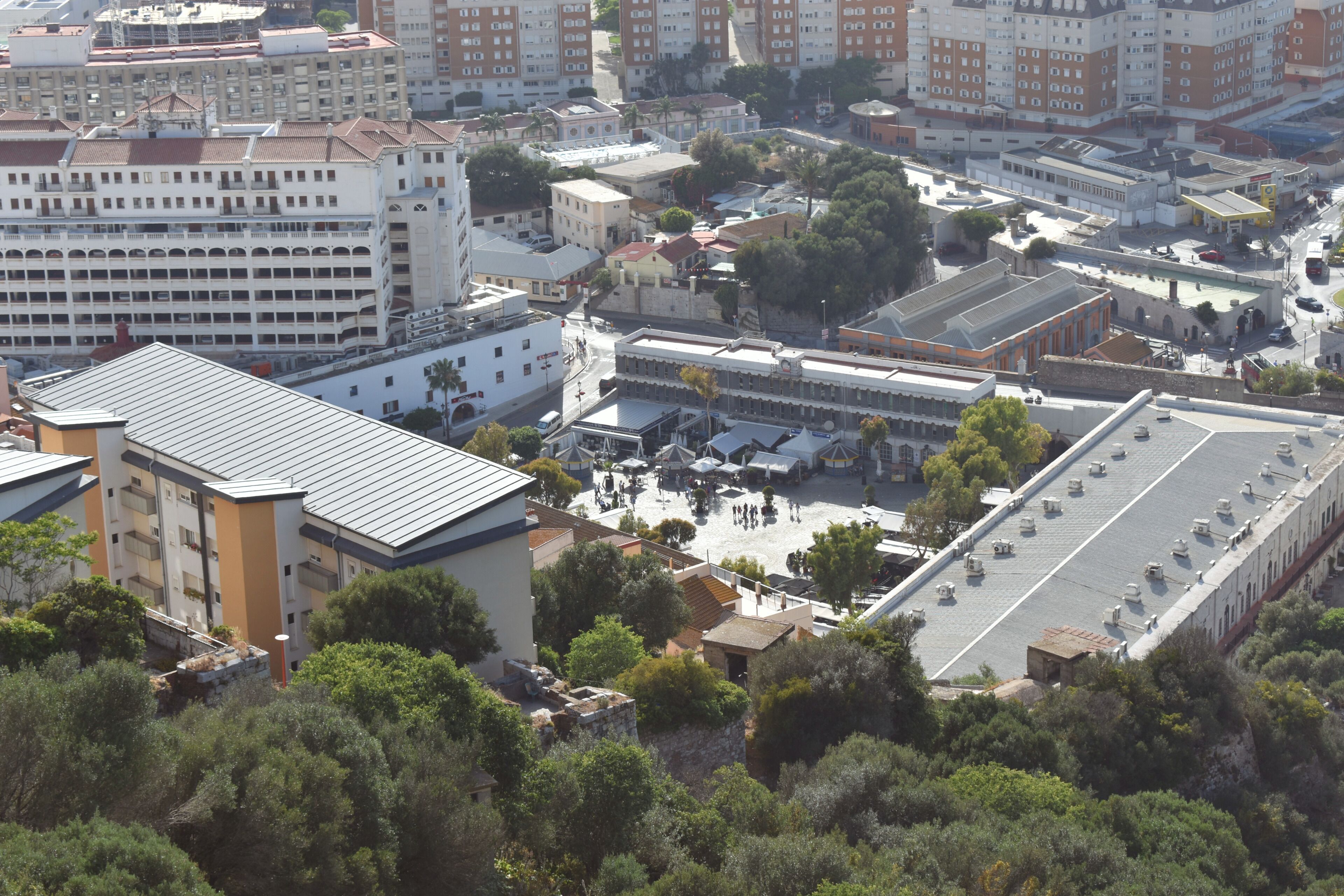 Zona urbana con edifici residenziali e commerciali, tra cui un grande hotel con cortile centrale e diversi piani.