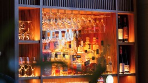 A bar area with shelves of liquor bottles and glasses. - Grand Halmstad, WorldHotels Crafted (Halmstad)