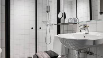 Une salle de bain moderne avec une douche à l’italienne en verre, un lavabo blanc au motif original et des toilettes noires.