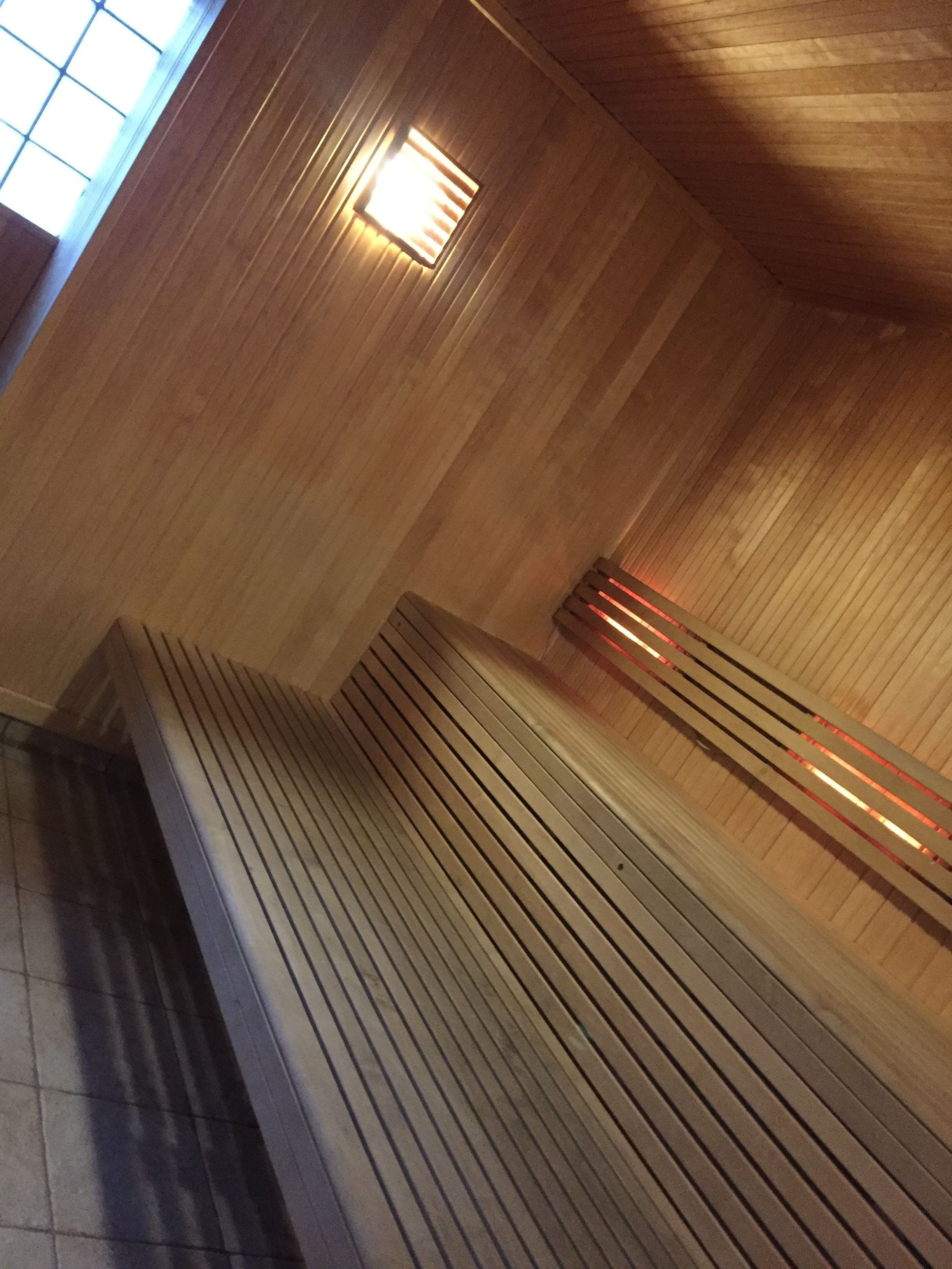 Un banc en bois doté d’un dossier incliné et d’une assise en bois à motifs rayés.