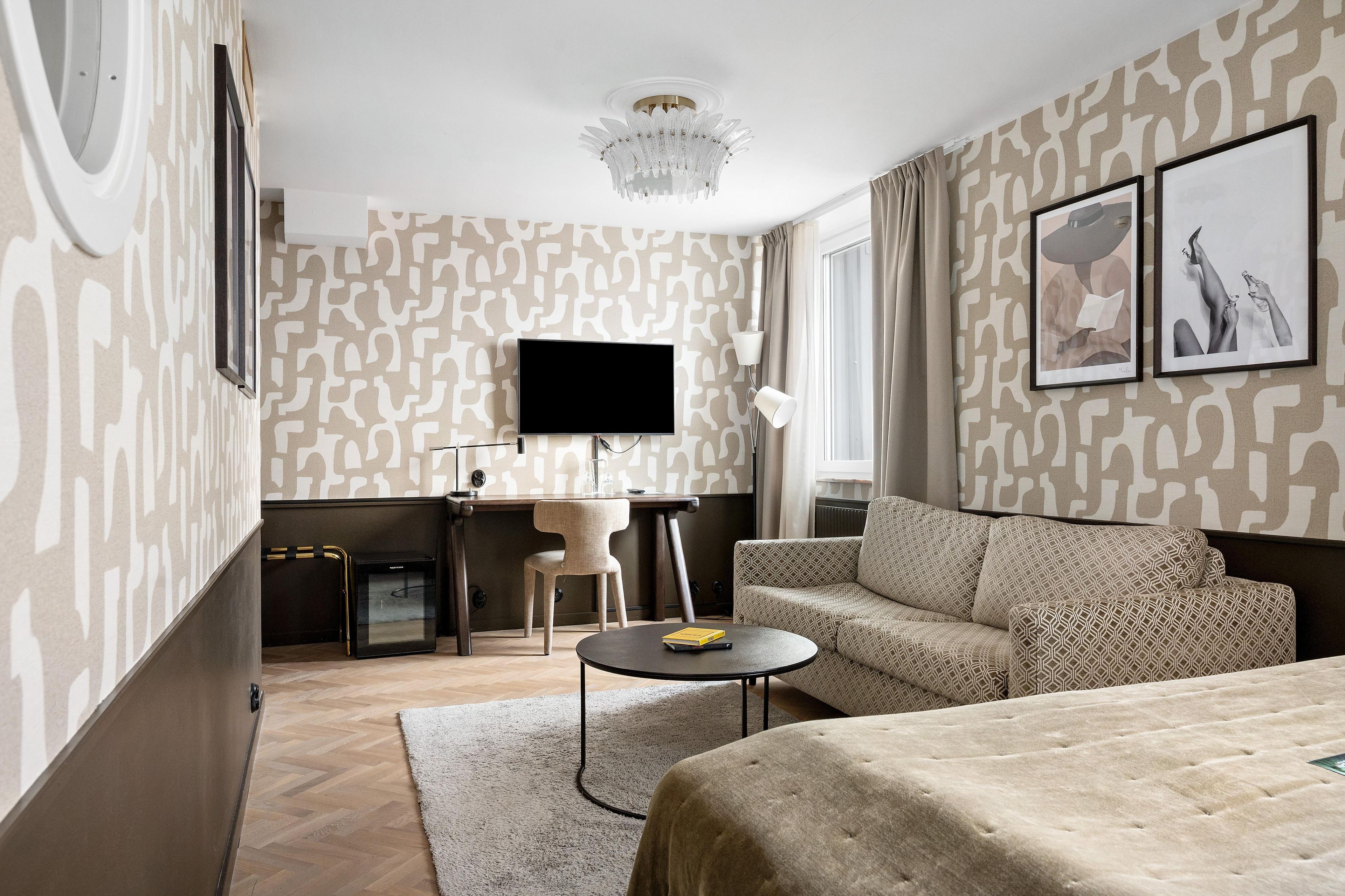 Une chambre d’hôtel avec un canapé, un bureau, une télévision et un lit.