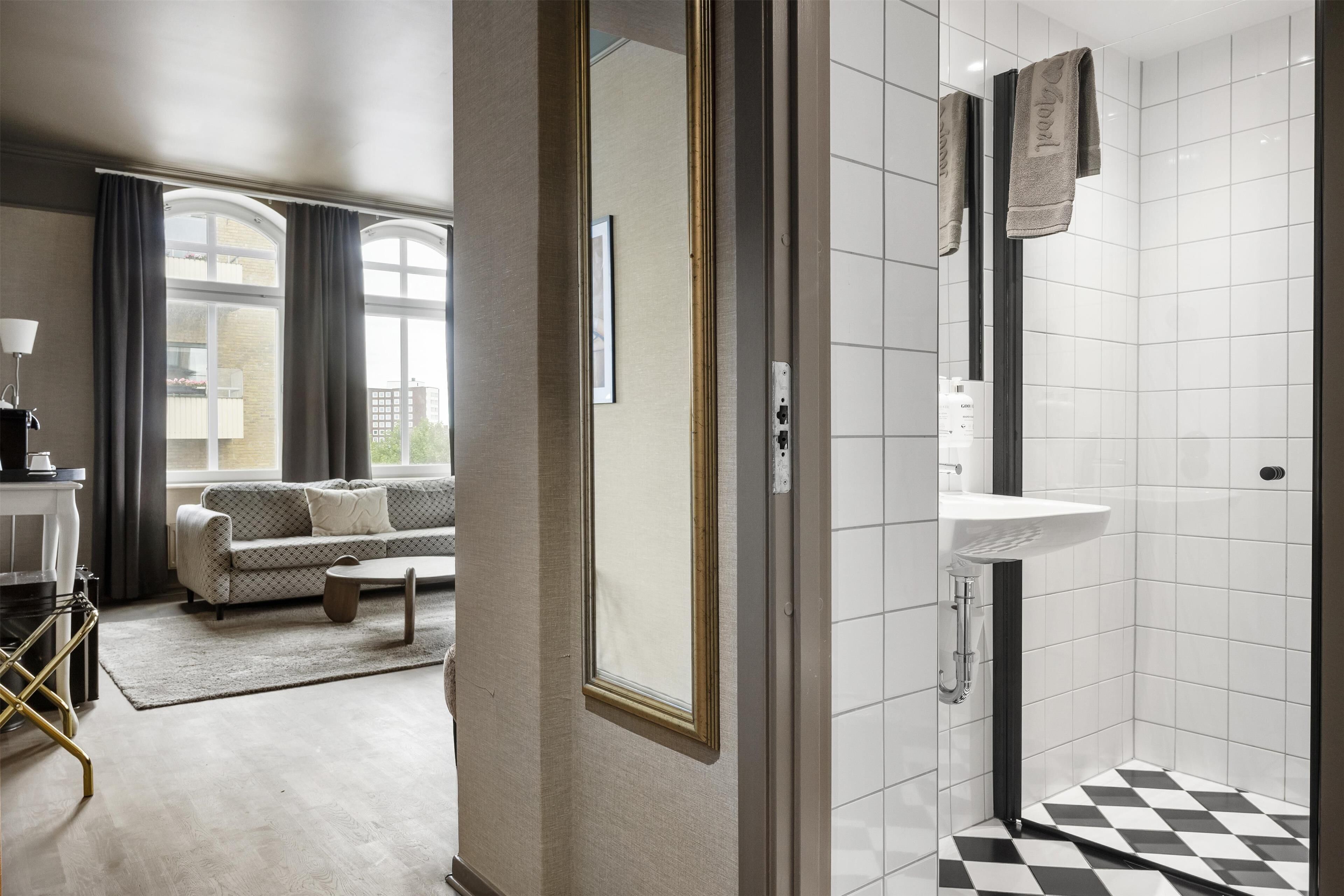 Ein modernes Badezimmer mit einem weißen Waschbecken und einem schwarz-weißen Schachbrettboden.