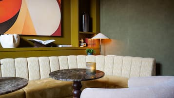 Relax in a stylish lounge area with a comfortable sofa, round table, and abstract artwork.