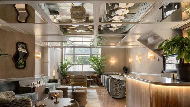 A modern lounge area with seating, a reception desk, and large windows providing natural light. - Grand Halmstad, WorldHotels Crafted (Halmstad)