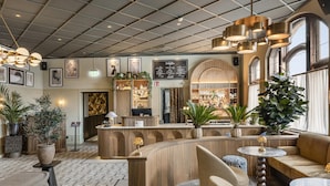 A modern hotel lobby with a reception desk, seating area, and large windows. - Grand Halmstad, WorldHotels Crafted (Halmstad)