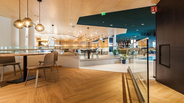 A modern interior with a wooden floor, glass partitions, and a central staircase. - Scandic Helsinki Aviacongress (Vantaa)