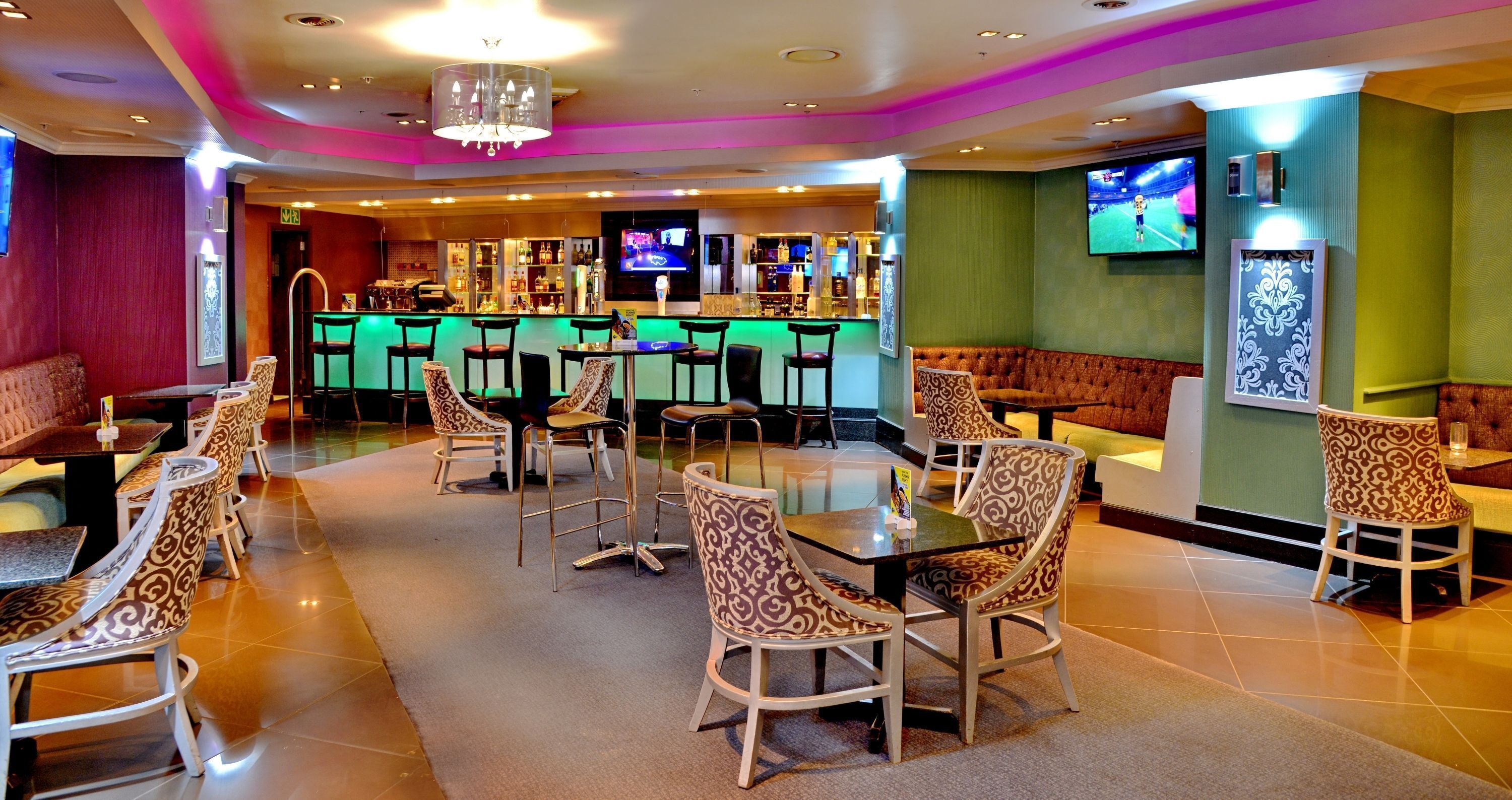 A bar area with seating, a television, and a bar counter.