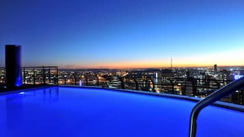 Una piscina al aire libre, sillones reclinables de piscina