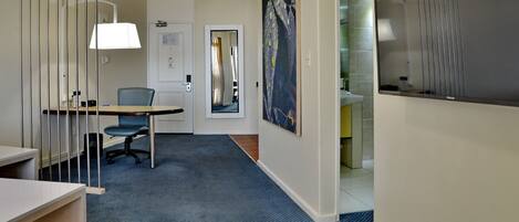 A modern office space with a desk, chair, and a large painting on the wall.