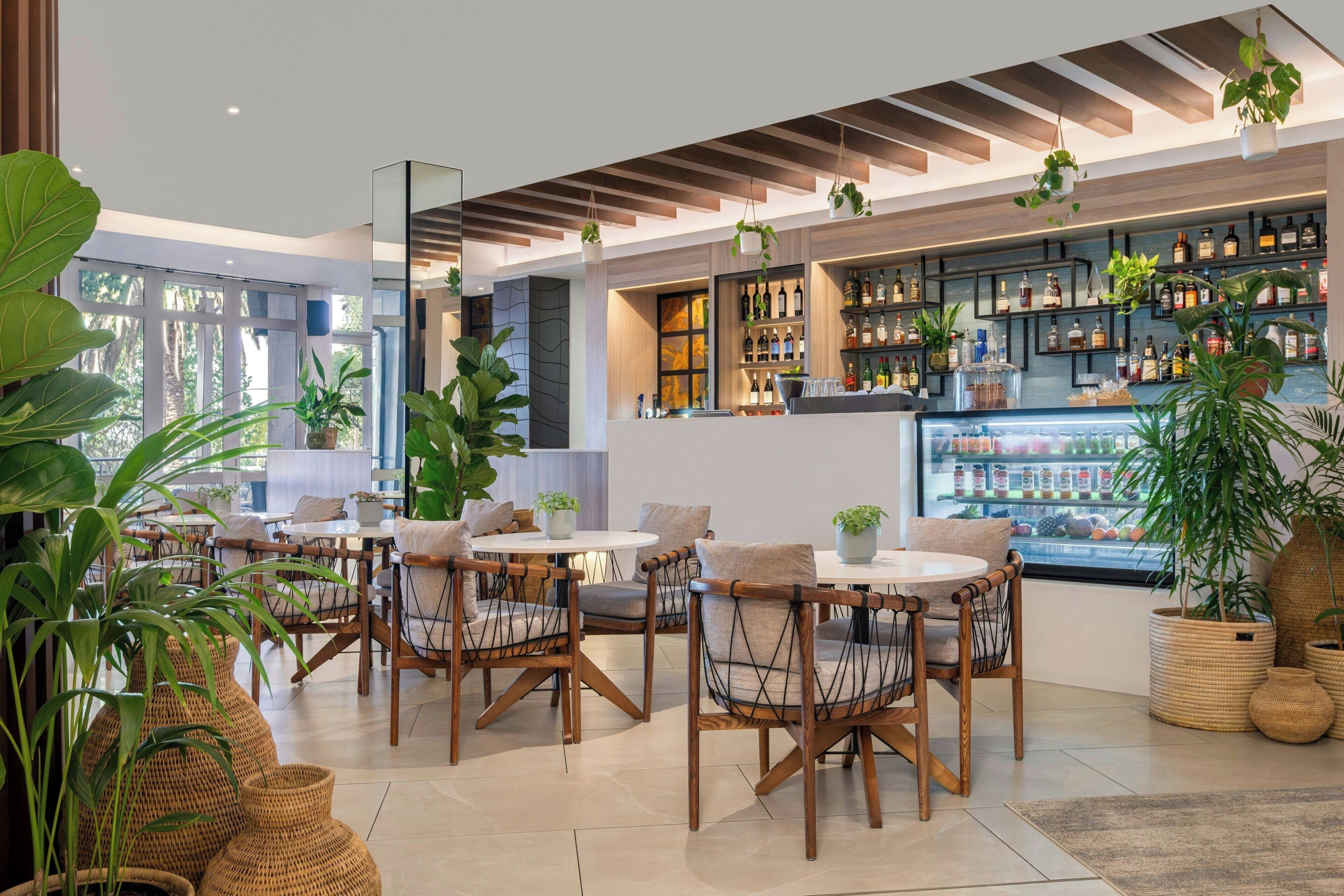 A modern bar area with seating and a variety of bottles.