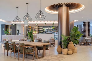 A modern interior with a bar area, seating, and decorative plants.