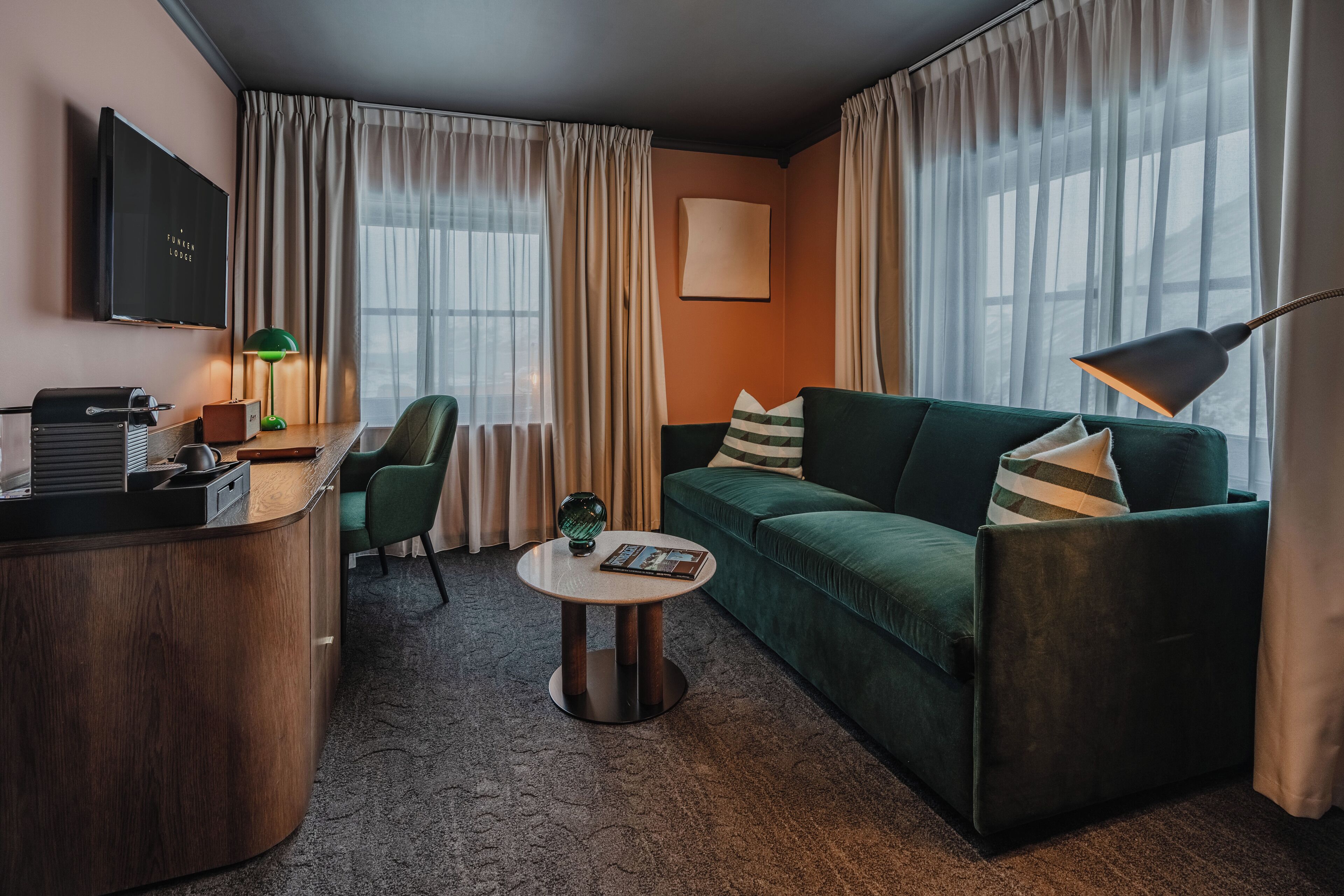 Suite, 1 cama matrimonial | Área de sala de estar | Televisión de pantalla plana y libros 