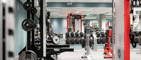 A gym with various exercise equipment, including weight machines and dumbbells.