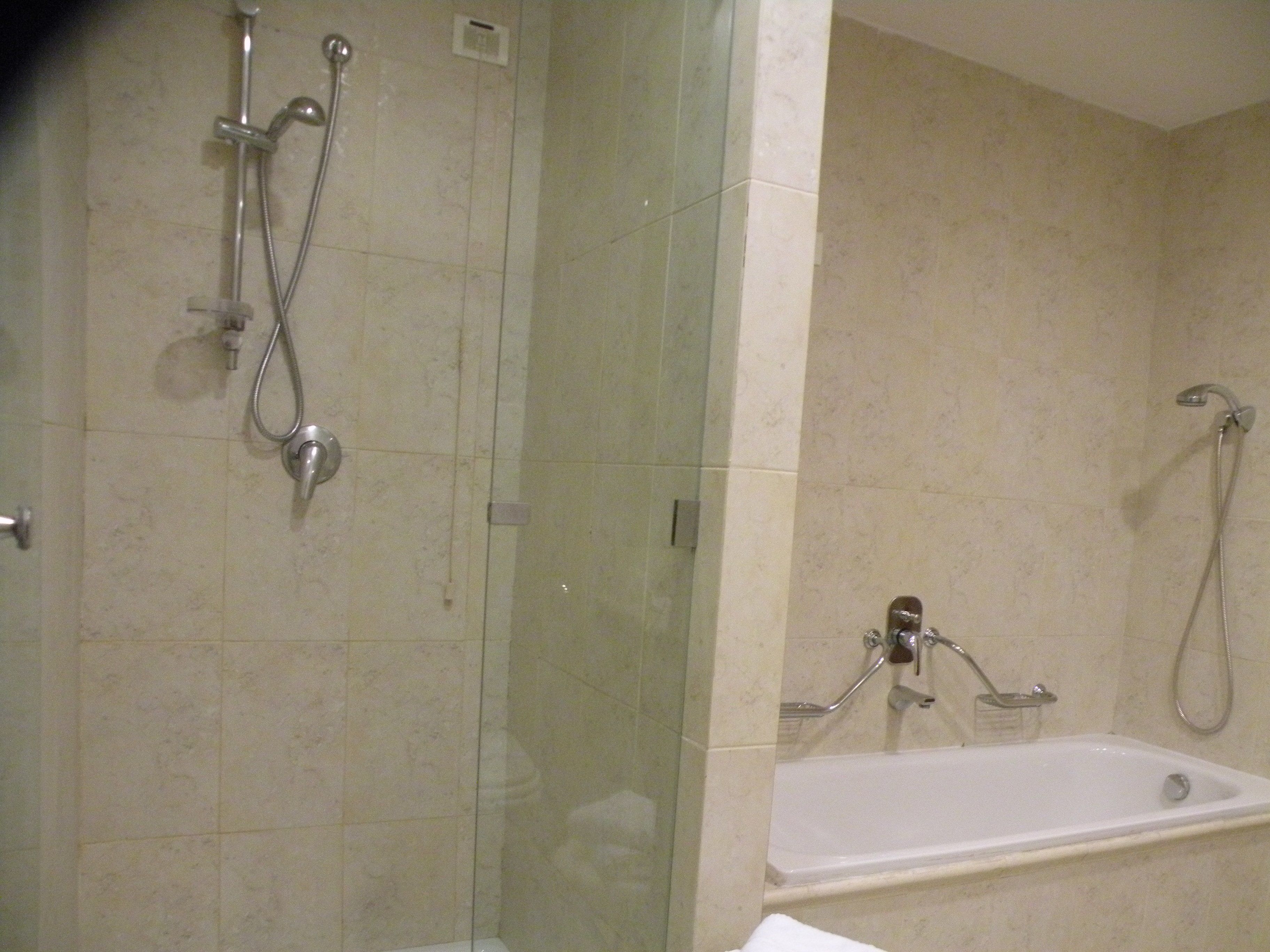 Ein Badezimmer mit einer Duschkabine, einer Badewanne und einem Waschbecken.