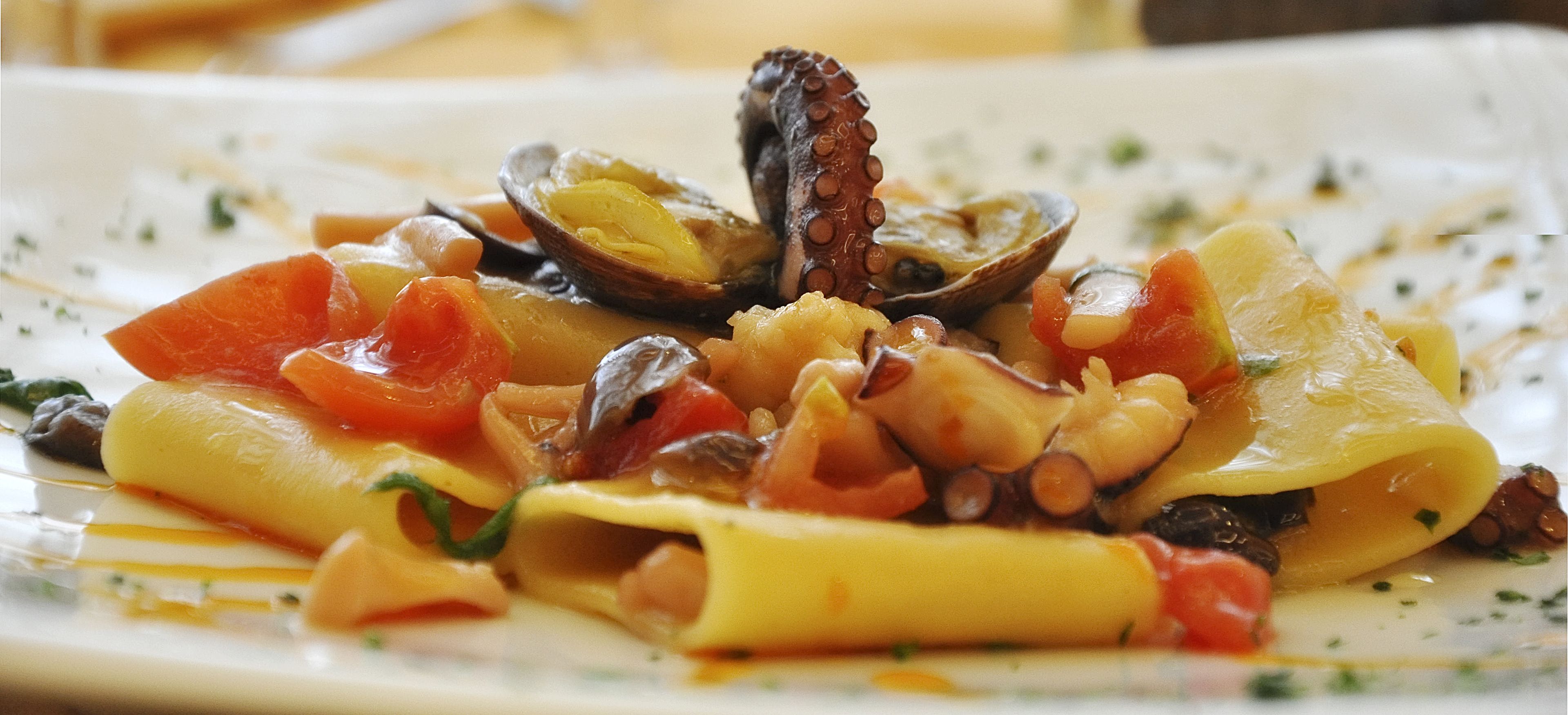 Een bord pasta met zeevruchten en groenten.