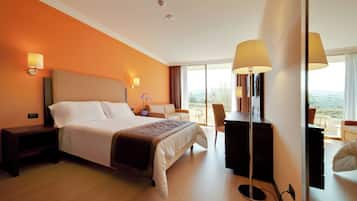 Habitación de hotel con una cama grande, lámparas de noche, un escritorio y vistas al exterior.