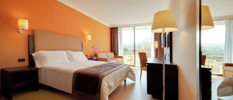 Habitación de hotel con una cama grande, lámparas de noche, un escritorio y vistas al exterior.