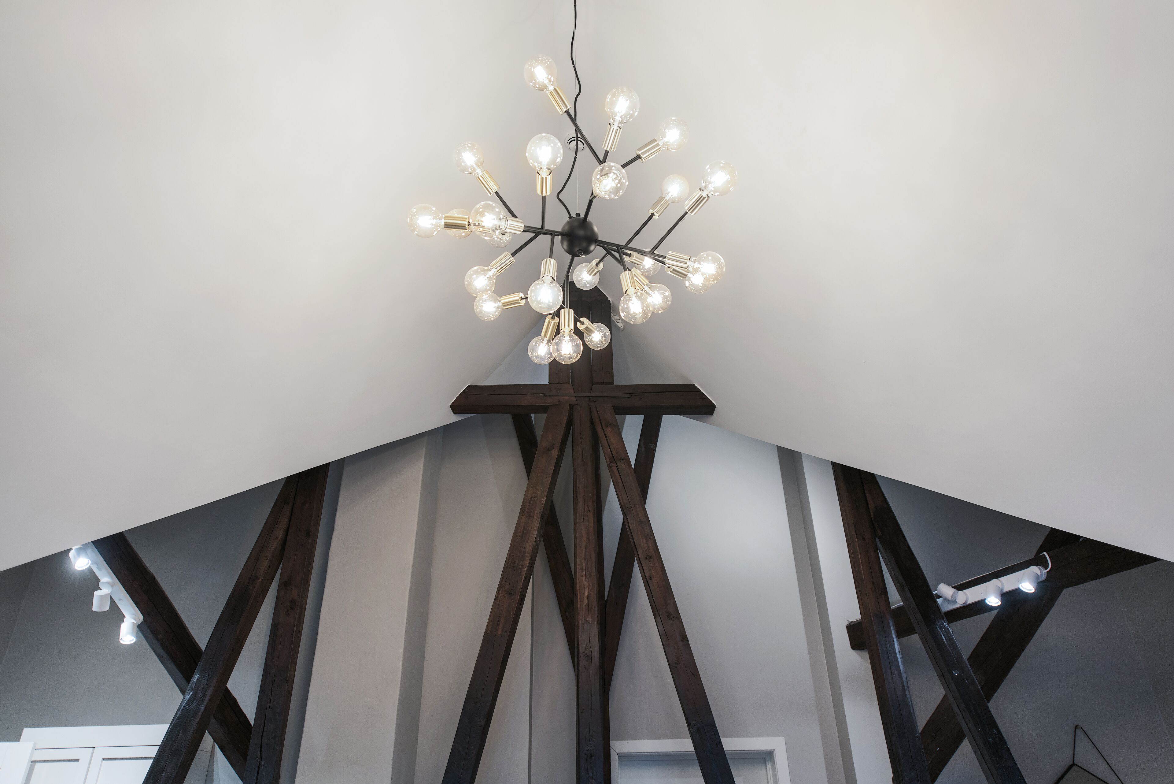 Un candelabro moderno con múltiples bombillas esféricas, sujeto a un soporte de madera.