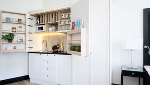 A compact kitchen with built-in storage, a microwave, and a small dining area. - Frogner House - Bygdøy Allé (Oslo)