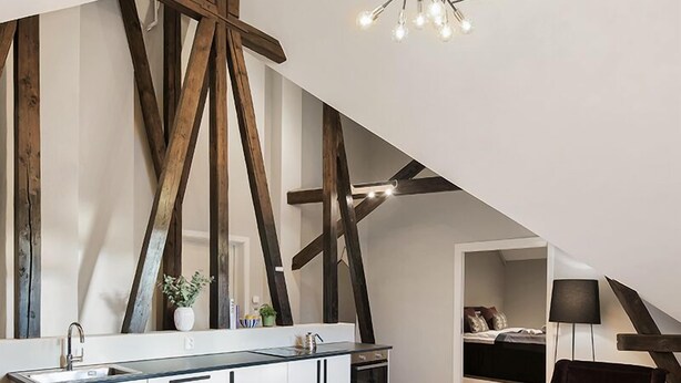 A modern kitchen with a central island, wooden beams, and a hanging light fixture. - Frogner House - Bygdøy Allé (Oslo)
