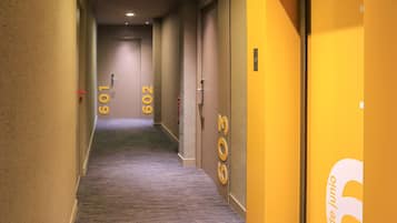 A hotel hallway with carpeted floors and doors numbered 601 and 602.