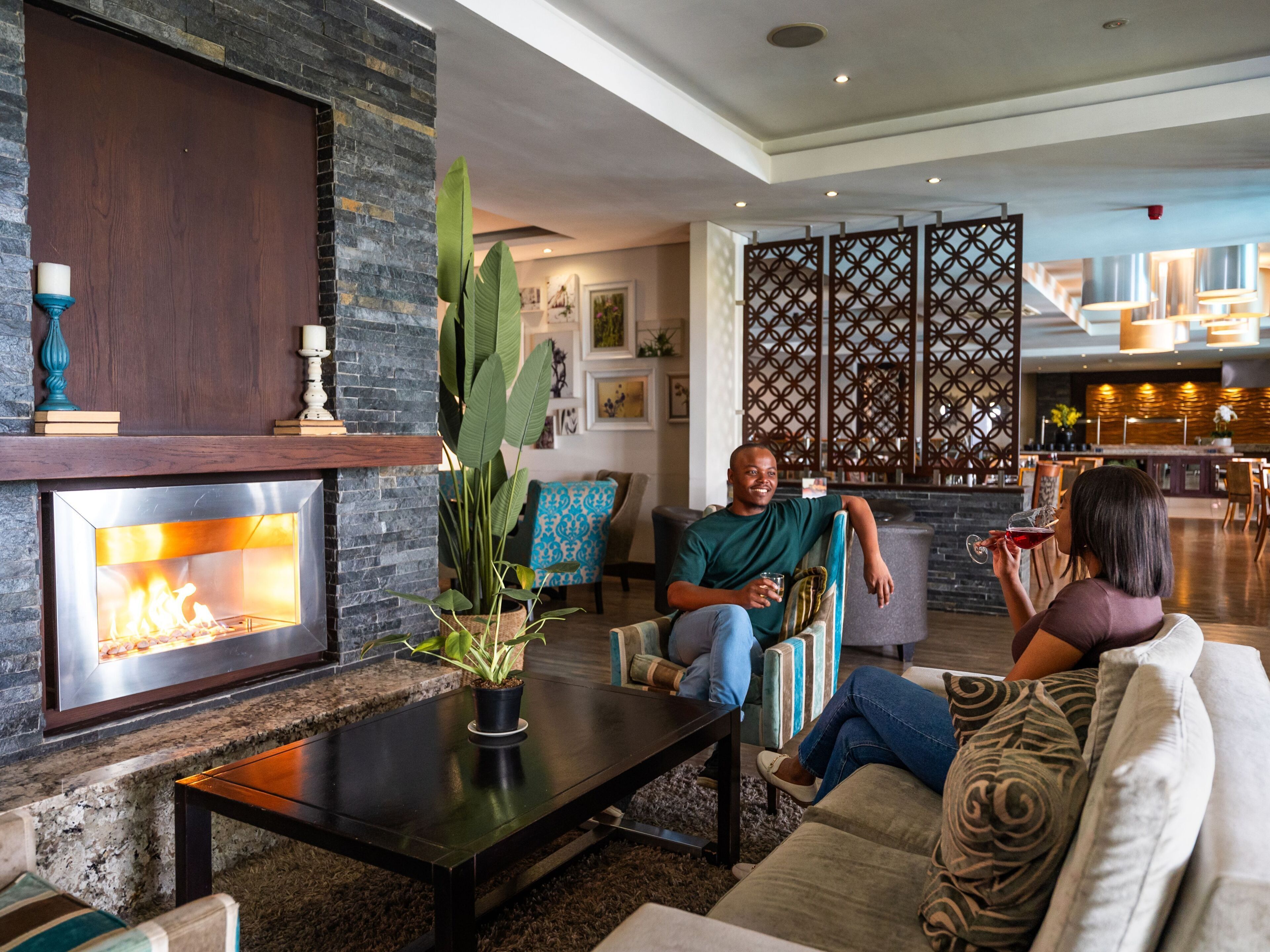 Un salon moderne avec une cheminée, des sièges confortables et une plante décorative.