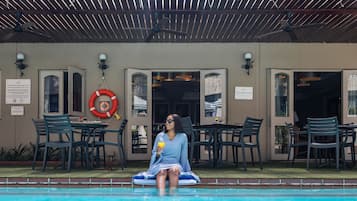 Una piscina al aire libre, tumbonas