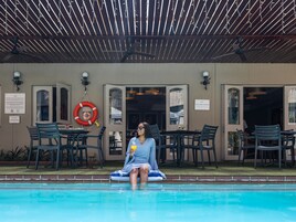 Una piscina al aire libre, sillones reclinables de piscina