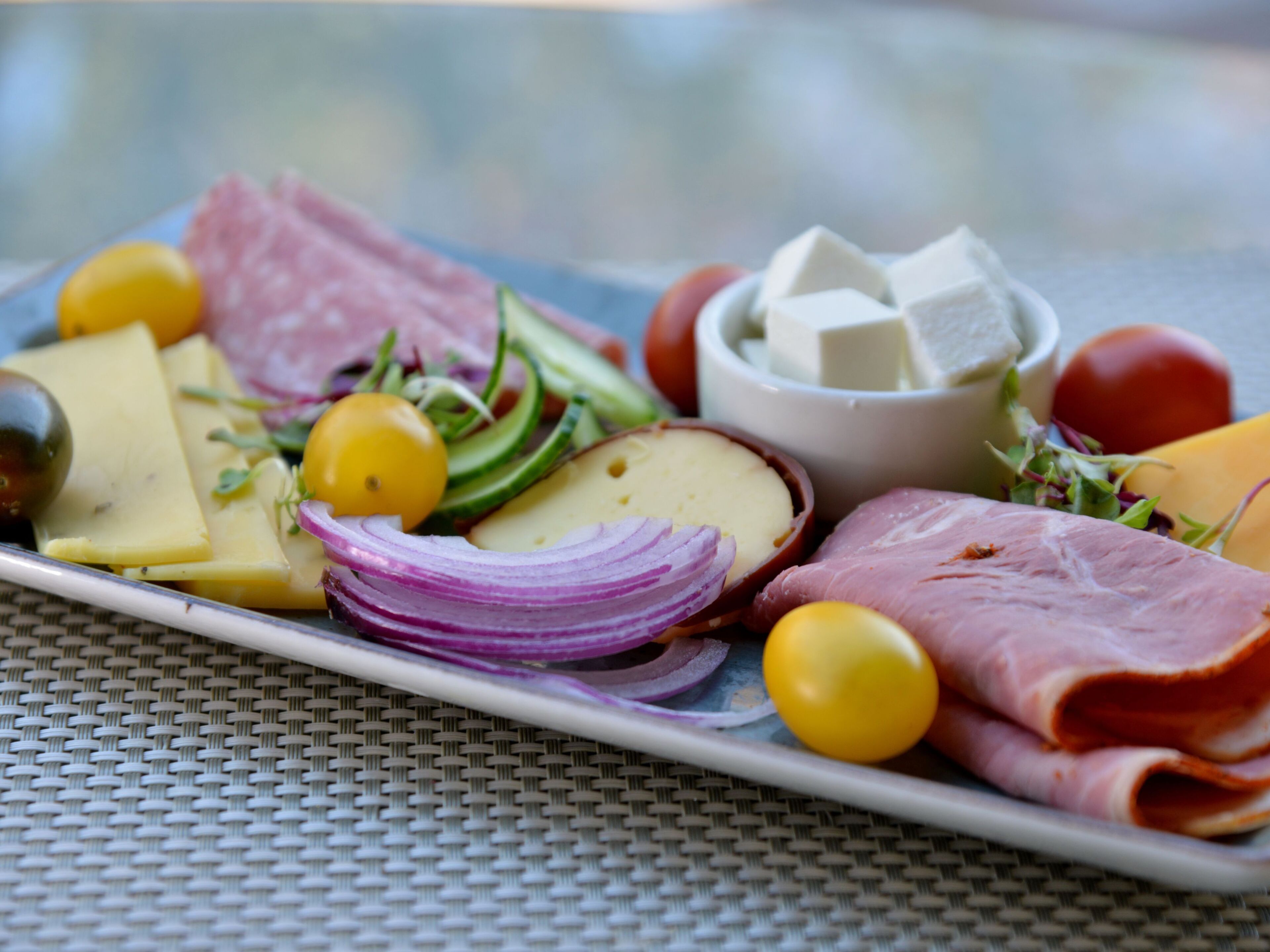 A plate of assorted cheeses, meats, and vegetables.