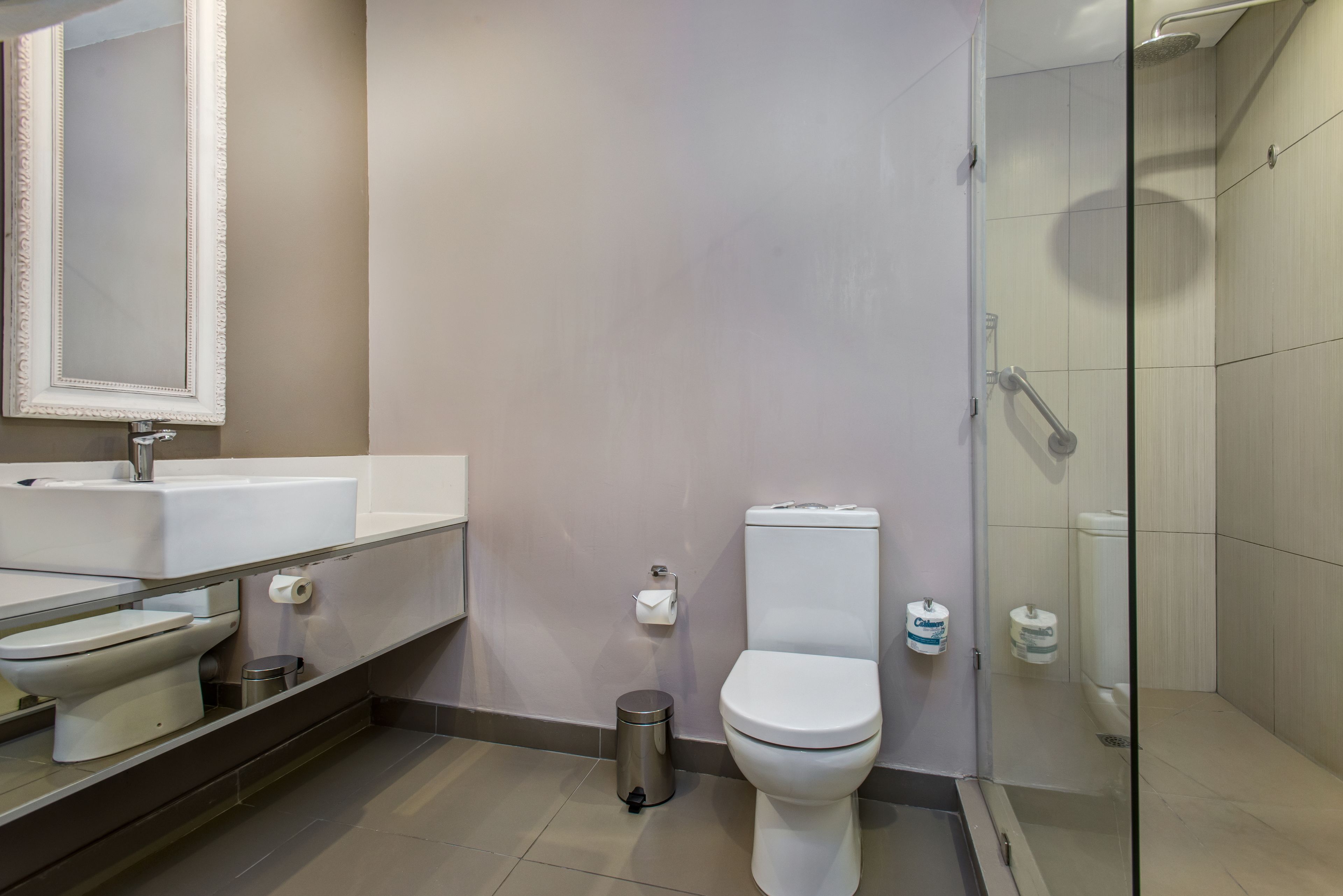 A modern bathroom with a toilet, sink, and shower.