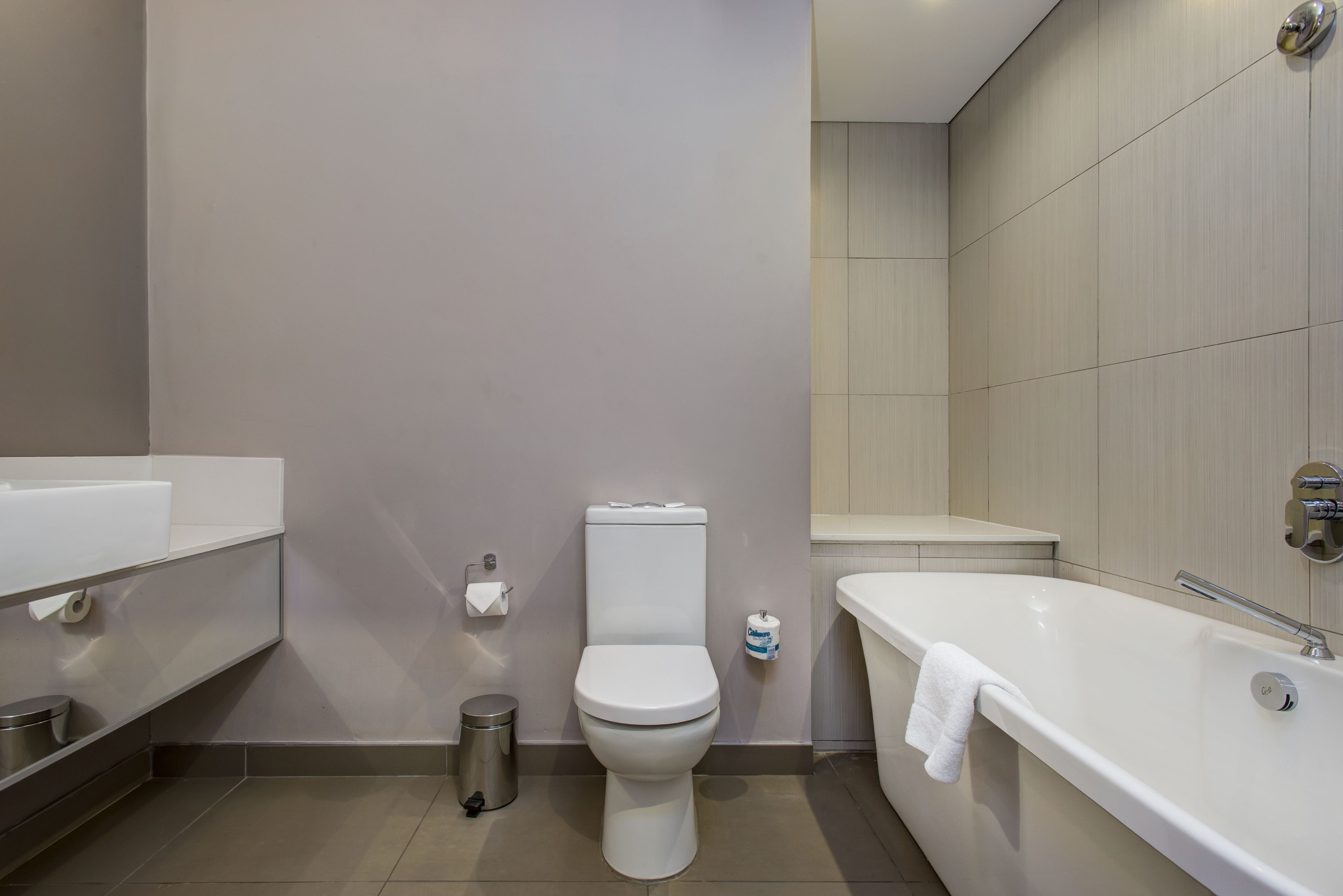 A modern bathroom with a toilet, a sink, and a bathtub.