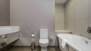 A modern bathroom with a toilet, a sink, and a bathtub.