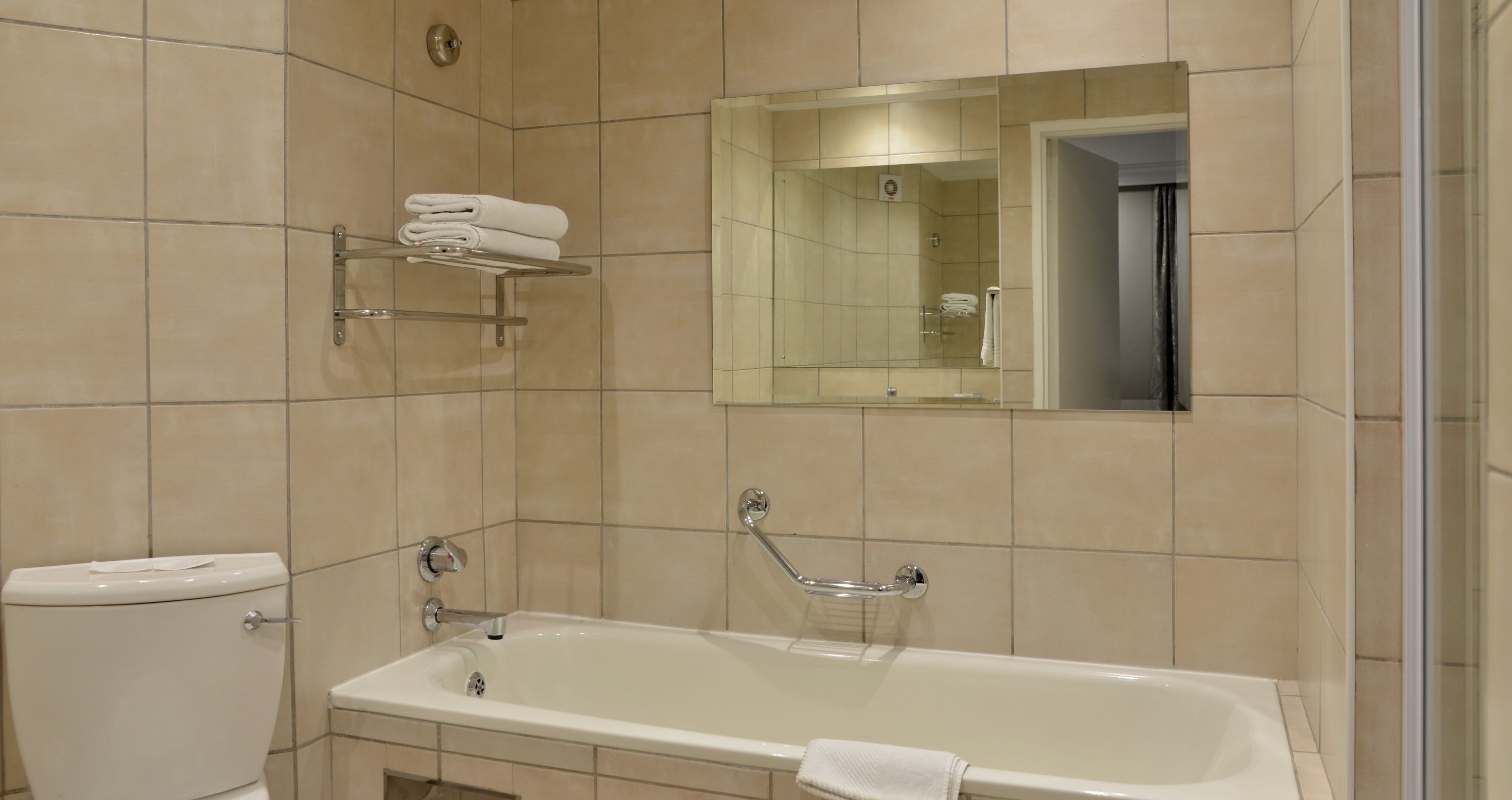 Ein Badezimmer mit Badewanne, Toilette und Handtuchhalter.