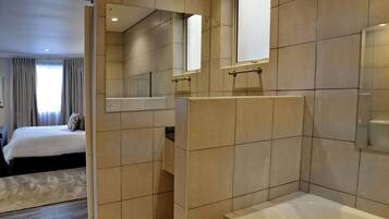 A modern bathroom with a bathtub, a shower area, and a mirror.