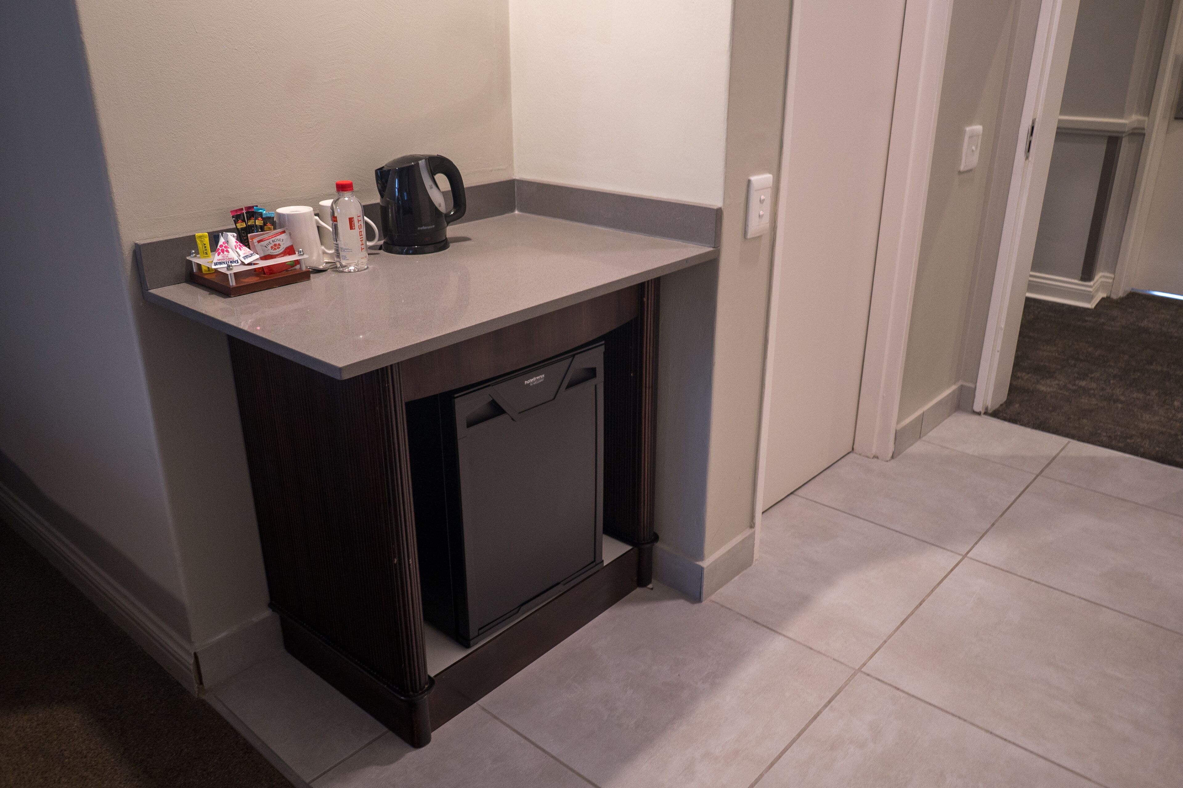 A compact kitchenette with a coffee maker, a microwave, and a small refrigerator.