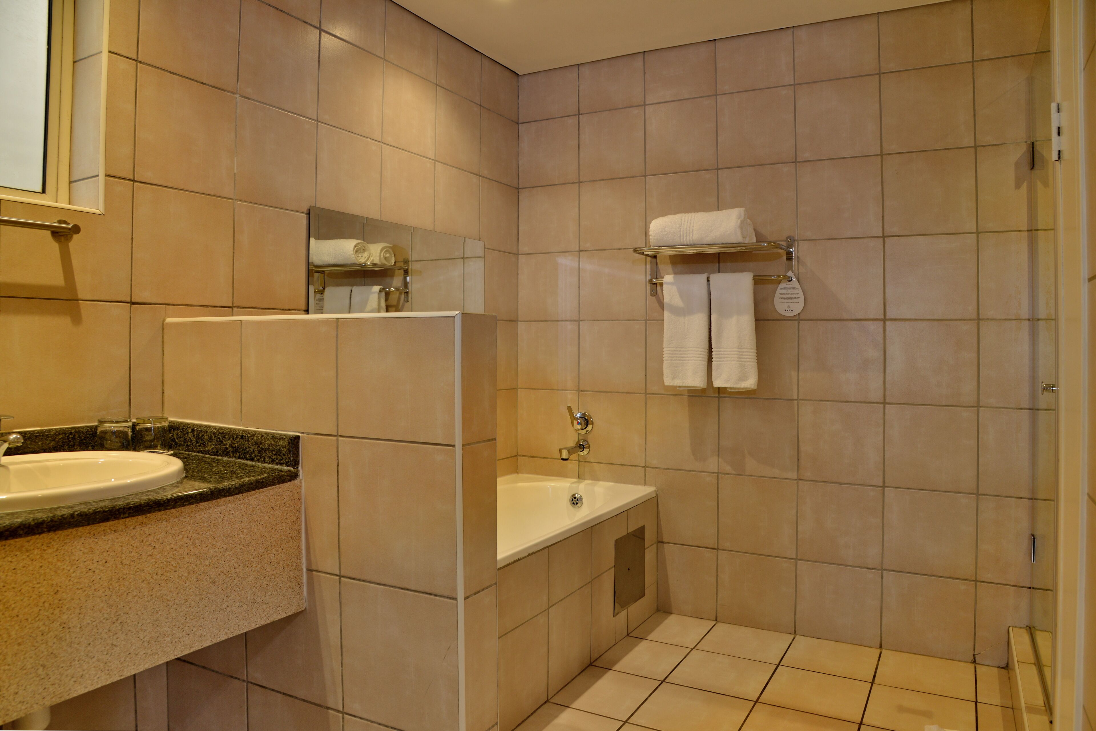 Une salle de bain moderne avec un lavabo, un miroir et une baignoire.