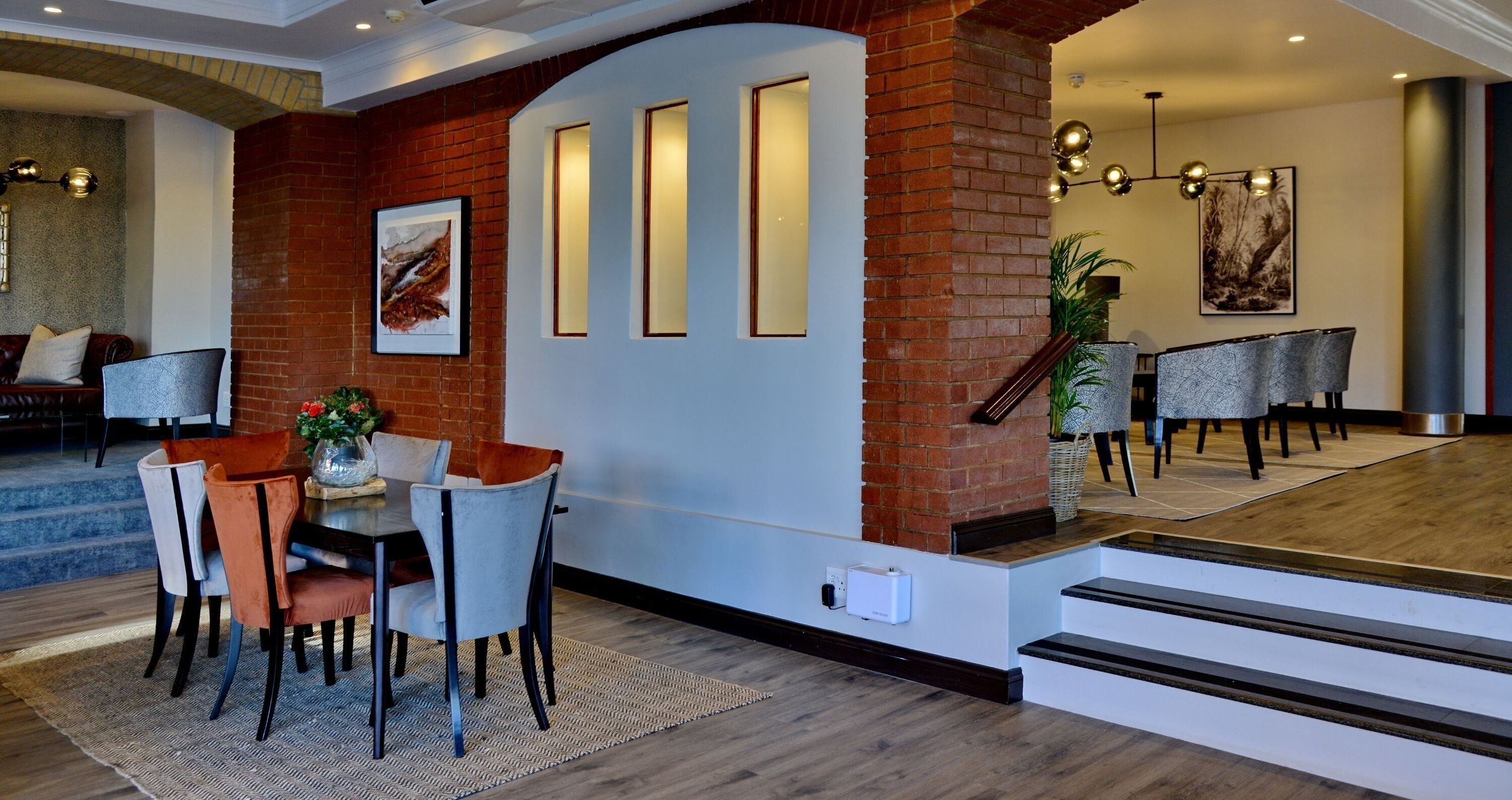 A modern interior with a dining area, a staircase, and a living room.