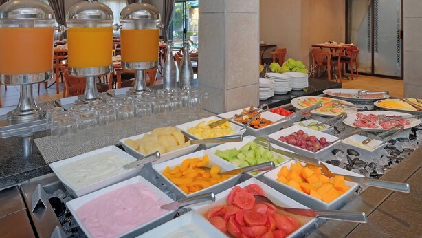 Un buffet proposant une variété de plats et des distributeurs de jus.