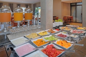 Un buffet proposant une variété de plats et des distributeurs de jus.