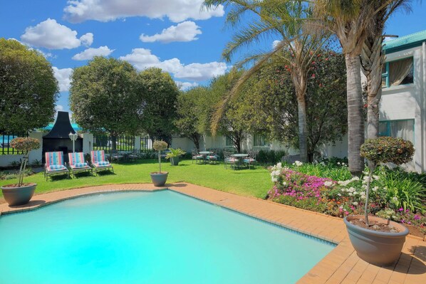 Alberca al aire libre, sombrillas en la alberca y camastros 