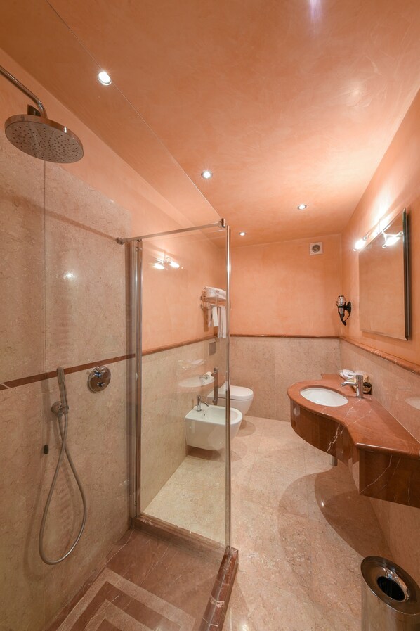 Un baño moderno con ducha de vidrio, inodoro y lavamanos.