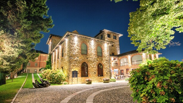 A historic stone building with arched windows and a courtyard with a gravel path. - Relais & Spa Castello di Casiglio (Erba)