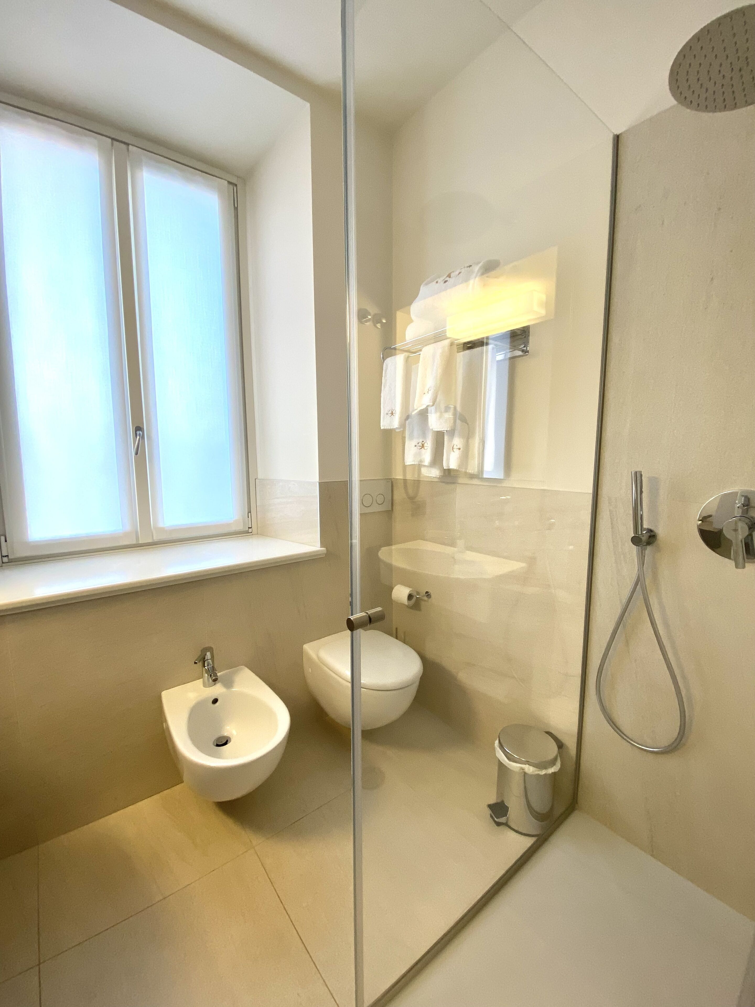 Un baño moderno con bidé, inodoro, lavabo y ducha.